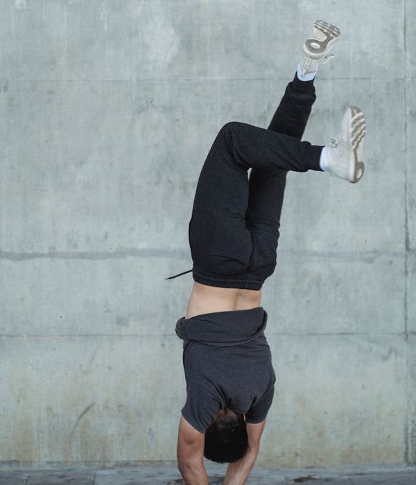 Man performing a controlled bodyweight exercise in a sunlit room.